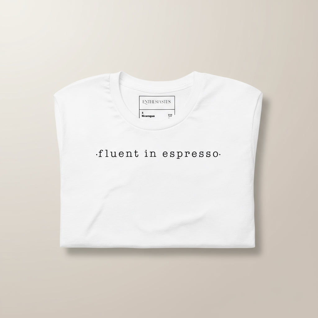 White unisex t-shirt with minimalist script 'fluent in espresso'