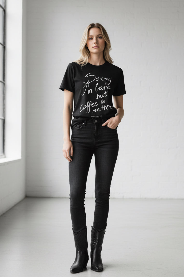 Black t-shirt with white text 'Sorry I'm late but coffee matters' on a white background