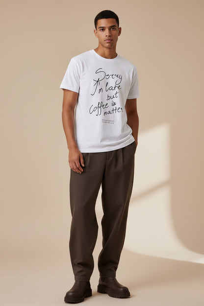 White t-shirt with black text 'Sorry I'm late but coffee matters' on a white background